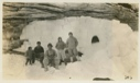 Image of Eskimos [Inughuit] in front of cave